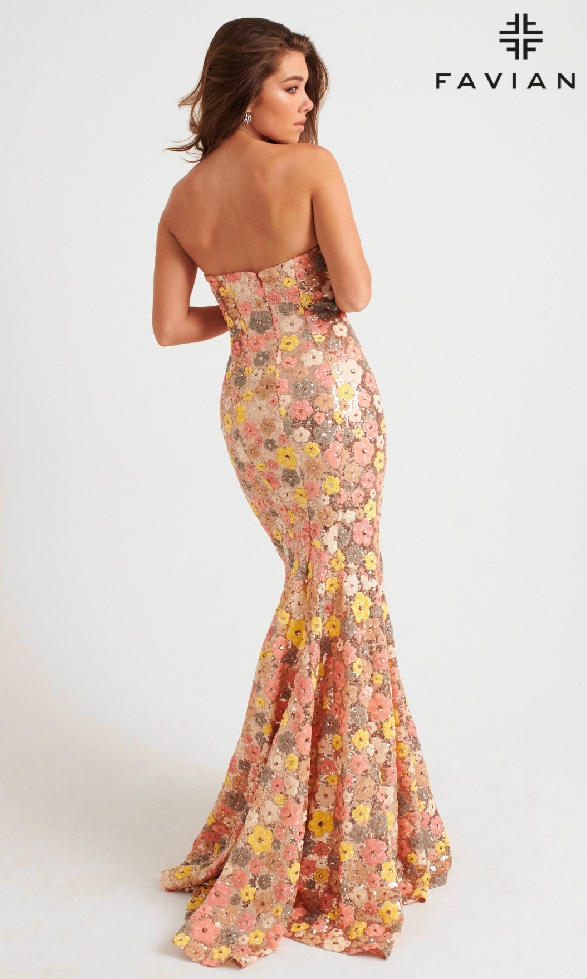 A woman models the Faviana Long Strapless Floral Prom Dress 11036, featuring sequins, a form-fitting silhouette, and flared hem, as she poses with her back to the camera against a plain light background with the